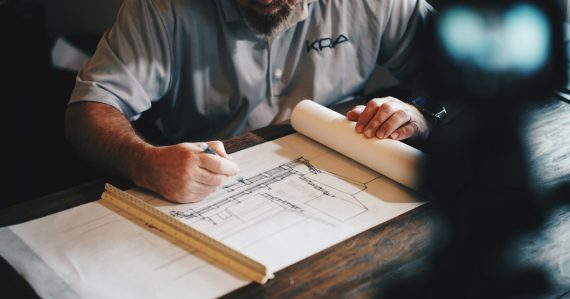 Architect drafting plans with a pencil and ruler, illustrating key questions for cloud planning