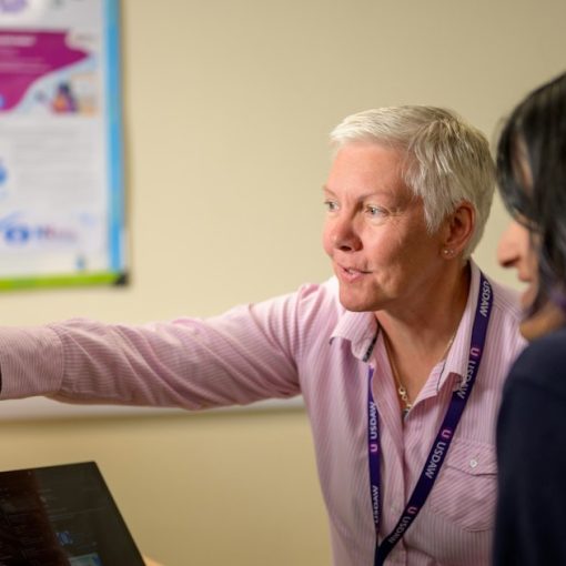 Colleagues working together at a computer, illustrating key skills IT pros need for cloud computing