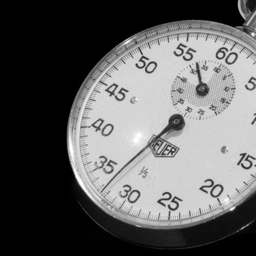 A close up of a stopwatch on a black background, illustrating latency in the cloud