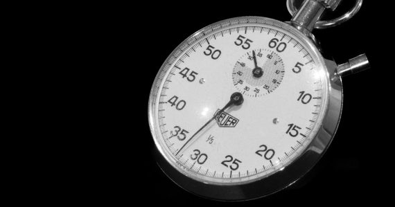 A close up of a stopwatch on a black background, illustrating latency in the cloud