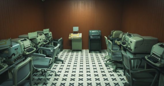 A room filled with lots of computers and desks, illustrating legacy IT holding back cloud adoption