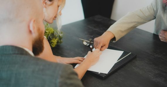 Couple signing document at desk, illustrating desktop virtualization licensing