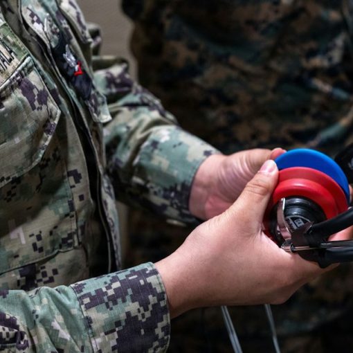 Two people in military uniforms holding headphones, illustrating military use of cloud computing