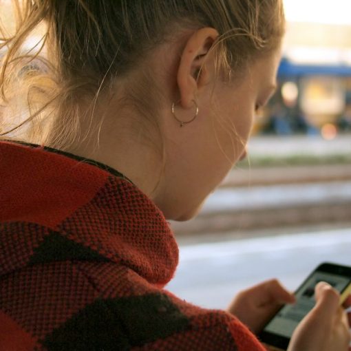Woman holding phone, illustrating virtualization on mobile devices