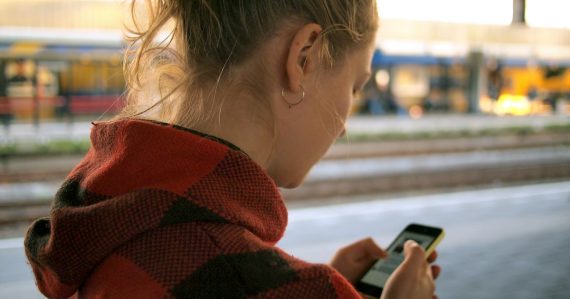 Woman holding phone, illustrating virtualization on mobile devices