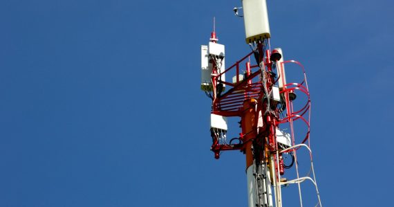 A cell phone tower with a blue sky in the background, illustrating mobility driving cloud adoption