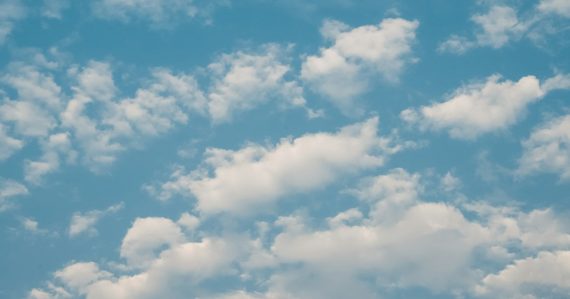 A plane flying in the sky with a lot of clouds, illustrating navigating cloud options for SMBs