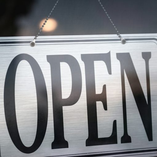 An open sign hanging on a glass door, illustrating the open cloud