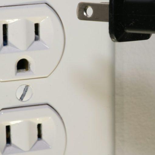 Black plug in front of electric socket, illustrating the need for open cloud standards