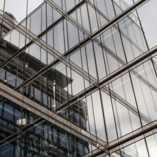 The reflection of a building in the windows of another building, illustrating phasing applications into the public cloud