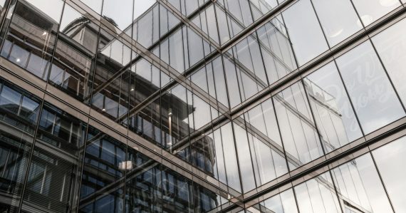 The reflection of a building in the windows of another building, illustrating phasing applications into the public cloud