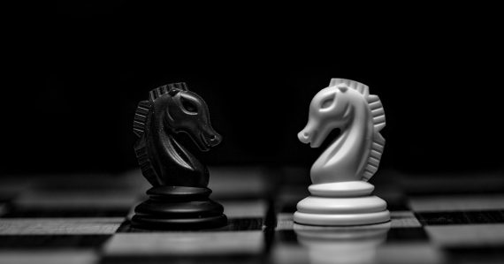 A black and a white chess knight facing each other, illustrating PaaS as the next cloud battleground