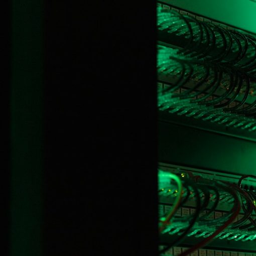 Server rack with glowing network cables in a data center, illustrating predicting workload for online services