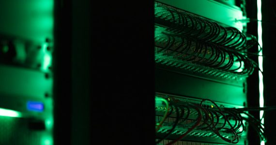 Server rack with glowing network cables in a data center, illustrating predicting workload for online services