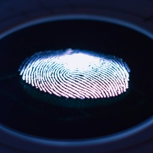 A glowing fingerprint on a dark scanner, illustrating identity, privacy and trust in the cloud