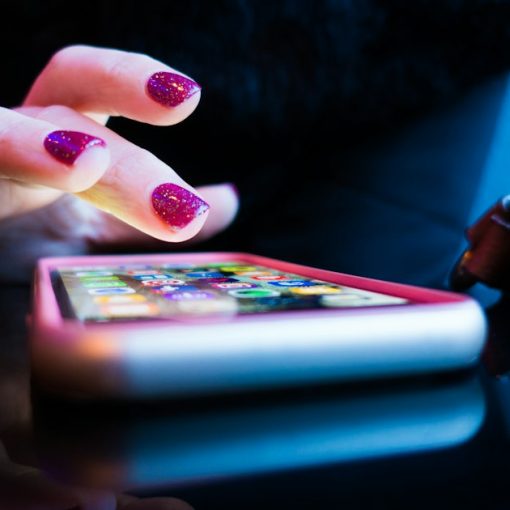 Person using black smartphone with gray and pink case, illustrating public cloud for mobile apps