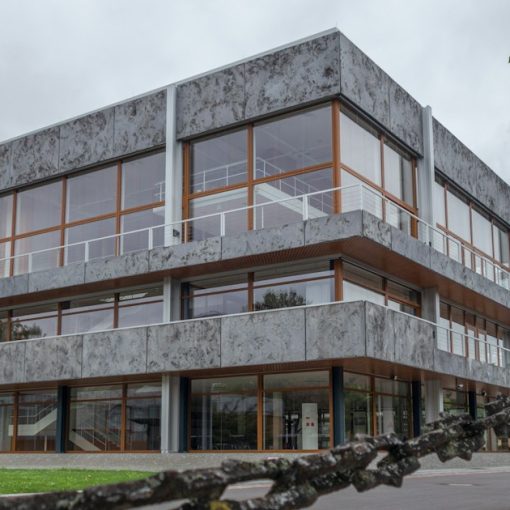 Modern concrete building with large windows and a chain fence, illustrating public sector cloud revenue growth