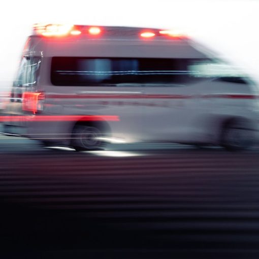 An ambulance driving down the street with lights flashing, illustrating a cloud application that saves lives