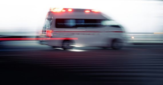 An ambulance driving down the street with lights flashing, illustrating a cloud application that saves lives