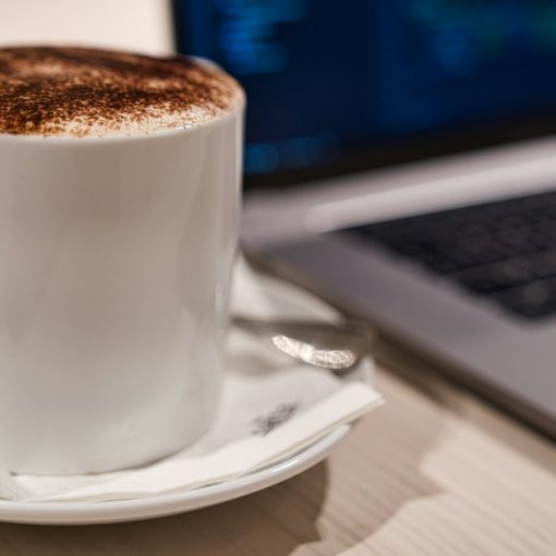 Cappuccino in a cup beside a laptop, illustrating IBM streaming enterprise desktops from the cloud