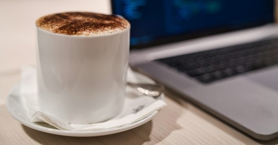 Cappuccino in a cup beside a laptop, illustrating IBM streaming enterprise desktops from the cloud
