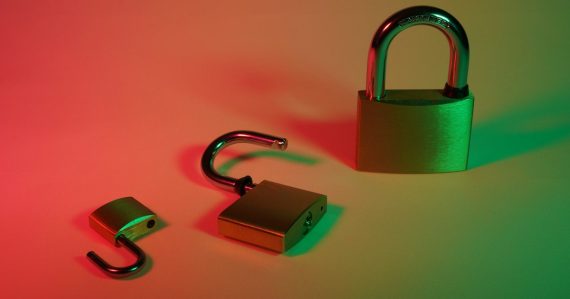 Green and silver padlock on yellow surface, illustrating securing VoIP for small businesses