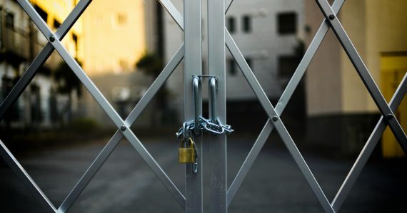 Gray steel gate closed with padlock, illustrating securing the cloud