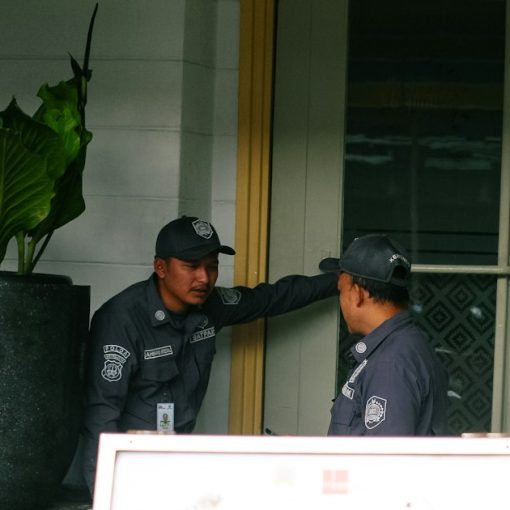 Two security guards talking near a large potted plant, illustrating virtualization changing security practices