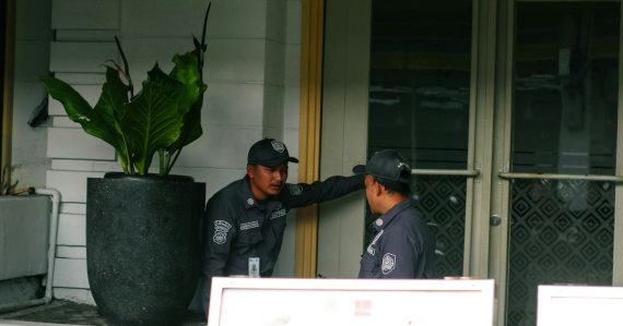 Two security guards talking near a large potted plant, illustrating virtualization changing security practices