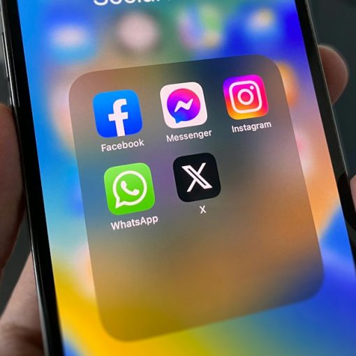 A person holding a cell phone with social media on the screen, illustrating pressure on security professionals