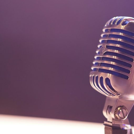 A vintage silver microphone with blue accents against a soft purple background, illustrating VoIP security concerns
