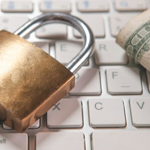 A padlock and dollar bills on a computer keyboard, illustrating cloud security for small businesses