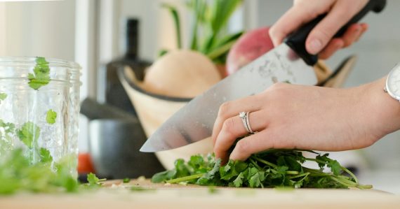Person cutting vegetables with knife, illustrating reducing OPEX with desktop virtualization