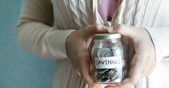 A woman holding a jar with savings written on it, illustrating small companies seeking cloud savings