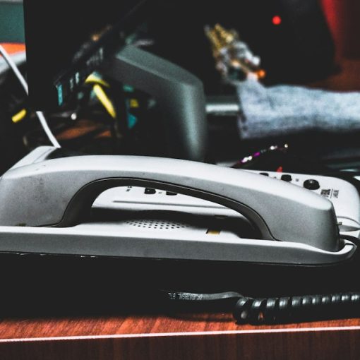 A desk with a phone, pencils, pens, and other office supplies, illustrating a small business guide to VoIP