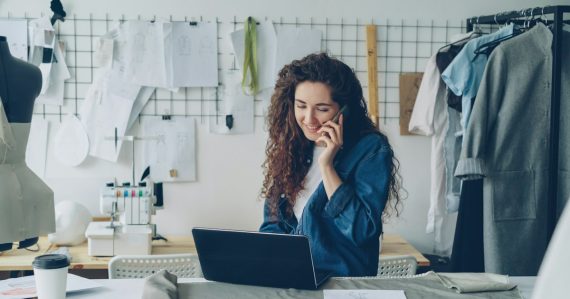 Small business owner on the phone working at a laptop, illustrating cloud adoption and revenue growth