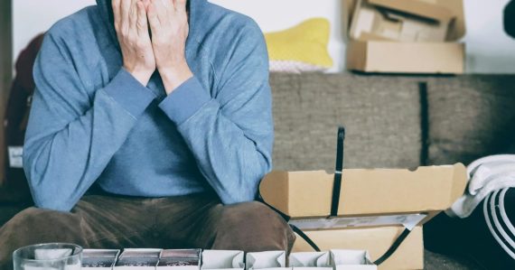 Man covering face with both hands while sitting on bench, illustrating SMBs struggling with virtualization