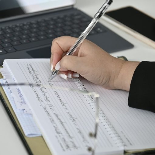 Person reviewing documents and writing notes, illustrating SOC 2 audit service standards