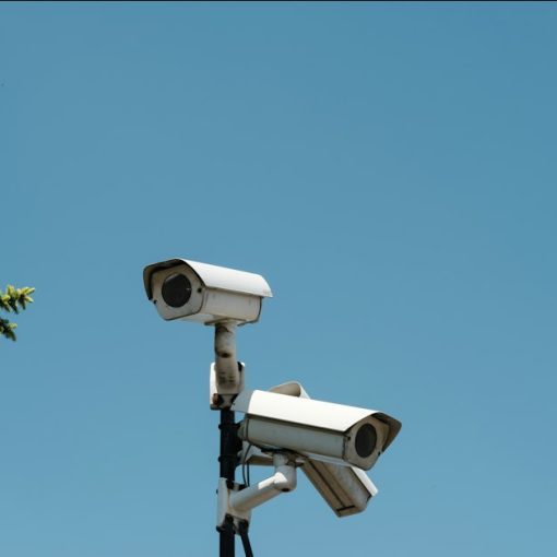 Two white security cameras mounted on a pole, illustrating US spy agencies adopting cloud computing