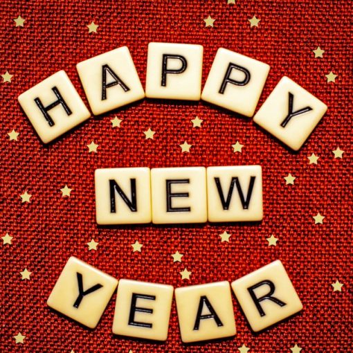 Happy new year spelled with letter tiles on a red background, illustrating storage trends in the new year