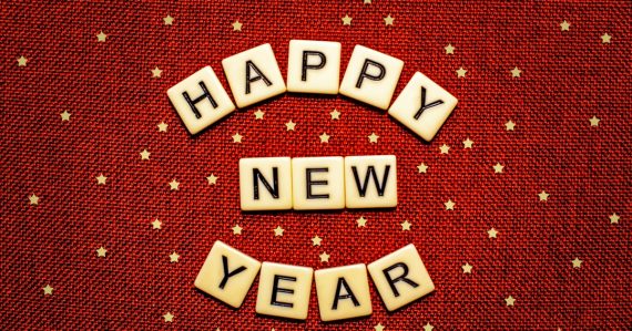 Happy new year spelled with letter tiles on a red background, illustrating storage trends in the new year