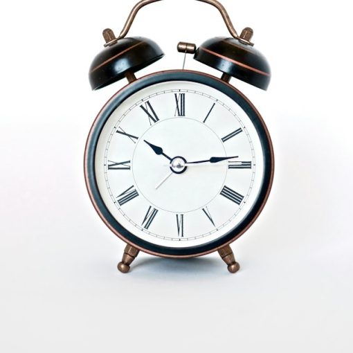 Round black and white analog alarm clock, illustrating strategic IT investment in a downturn