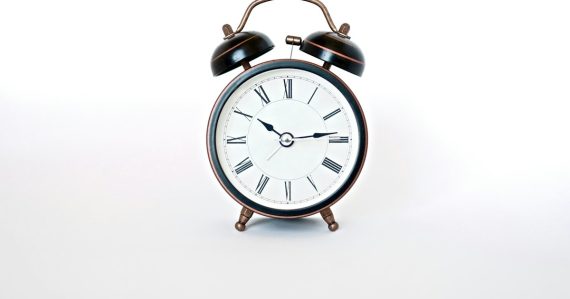 Round black and white analog alarm clock, illustrating strategic IT investment in a downturn