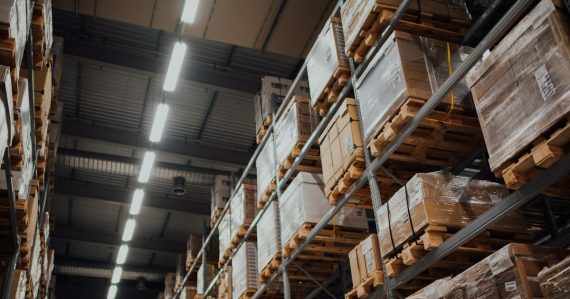 Brown cardboard boxes on white metal rack, illustrating the new IT supply chain