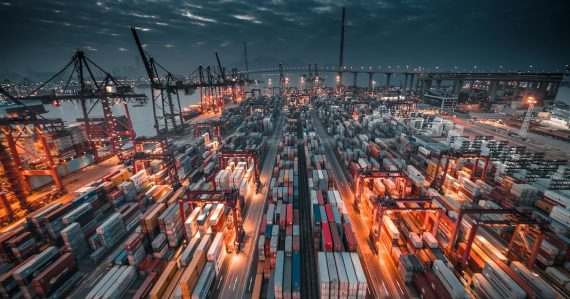 A busy shipping port with stacked containers and cranes, illustrating reshaping supply chain management with the cloud
