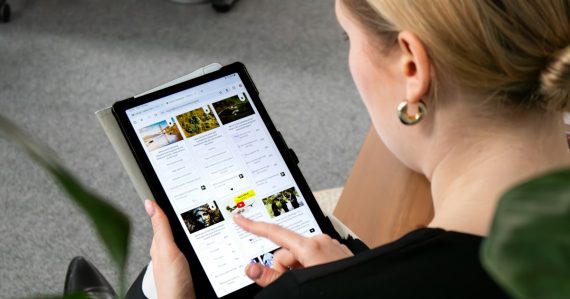 A woman sitting on the floor looking at a tablet, illustrating tablet security through virtualization