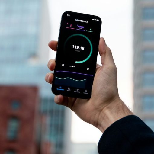 Hand holding a smartphone in a city, illustrating technologies shaping the future