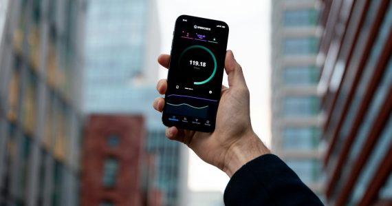 Hand holding a smartphone in a city, illustrating technologies shaping the future