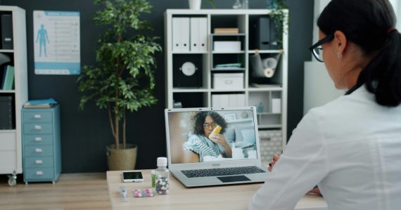 Doctor consulting patient via video call on laptop, illustrating telemedicine and cloud computing in healthcare