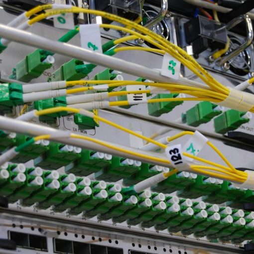 Fiber optic cables connected to a network switch in a server rack, illustrating thin clients and fast networks